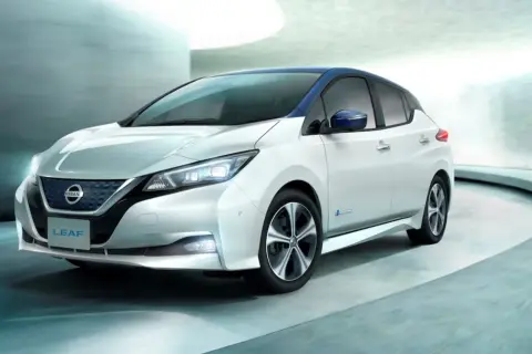 Biały Nissan Leaf z niebieskim dachem, nowoczesny design. Sprawdź nissan leaf cena i odkryj jego zalety.