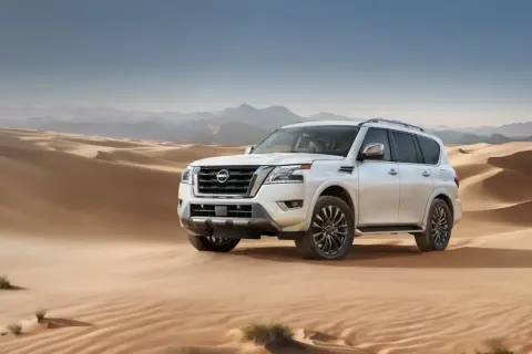 Biały Nissan Armada przemierza piaszczyste wydmy pustyni, gotowy na każdą przygodę.