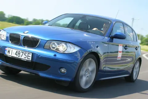Niebieskie BMW e81 z polskimi tablicami WI 4875E na zakręcie toru wyścigowego.