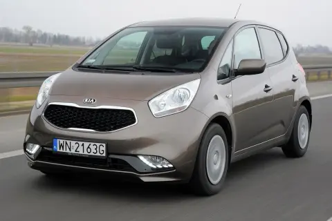 Brązowa Kia Venga jedzie po drodze.