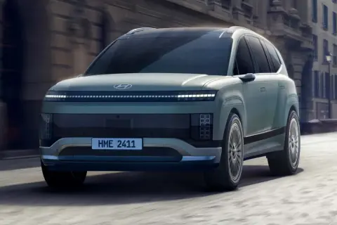 Przyszłościowy Hyundai Ioniq 9 w kolorze miętowym, poruszający się po miejskiej ulicy.