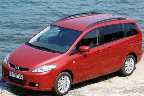 Czerwona Mazda 5 2.0 benzyna zaparkowana przy wodzie.