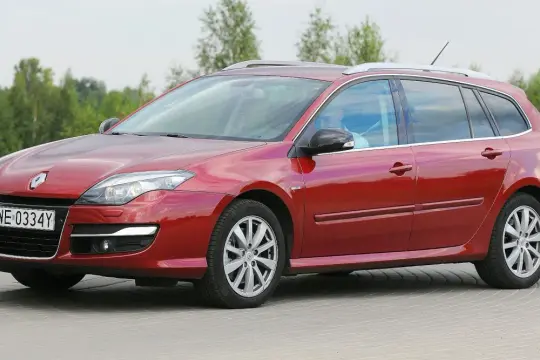 Czerwona Laguna 3 2.0 dCi kombi z polskimi tablicami WE 0334Y zaparkowana na zewnątrz.