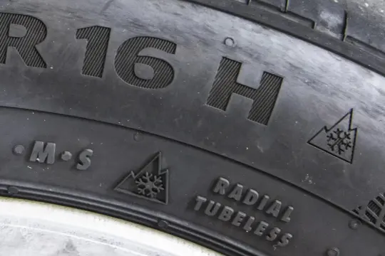 Oznaczenie opon wielosezonowych M+S z symbolem płatka śniegu w górach. Informacja o rozmiarze R16H i konstrukcji Radial Tubeless.
