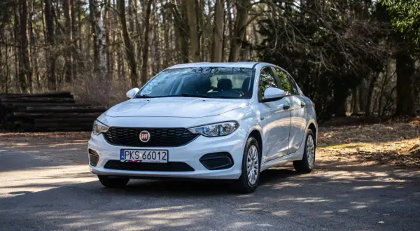 Biały Fiat Tipo na leśnej drodze. Wiele osób szuka pozytywnych fiat tipo opinie, a ten model wygląda na solidny wybór.