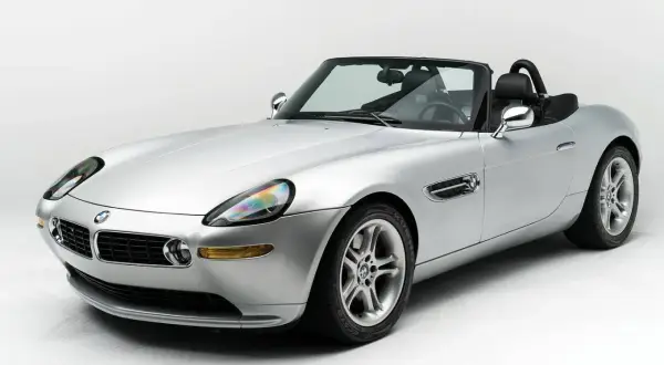 Srebrny kabriolet BMW Z8 na białym tle, z czarnym dachem i wnętrzem. Klasyk motoryzacji.