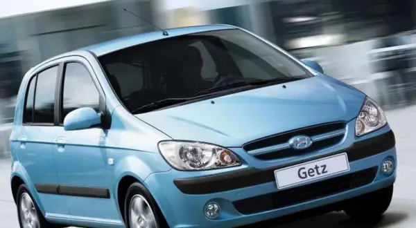 Błękitny Hyundai Getz w ruchu miejskim, z rozmytym tłem sugerującym prędkość.