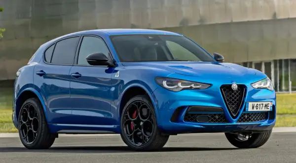Błękitne Alfa Romeo Stelvio Quadrifoglio z czarnymi felgami i czerwonymi zaciskami hamulcowymi, gotowe do dynamicznej jazdy.