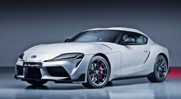Biała Toyota Supra GR z napisem "GR Supra" na grillu. Ta marka samochodu na zdjęciu to symbol sportowych osiągów.