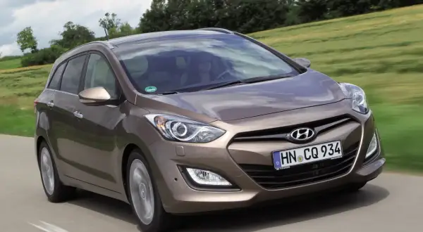 Brązowy Hyundai i30 1.4 benzyna w wersji kombi na drodze. Wiele pozytywnych hyundai i30 1.4 benzyna opinie o tym modelu.