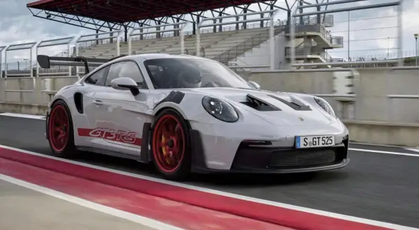 Biały Porsche 911 GT3 RS na torze wyścigowym. Sprawdź, jaka jest porsche 911 gt3 rs cena i poczuj moc tego auta.