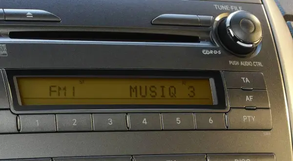 Radio samochodowe z wyświetlaczem RDS, pokazującym FM1 i MUSIQ 3. Przyciski numeryczne i sterowanie audio.