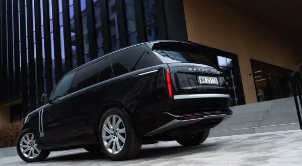 Elegancki czarny Range Rover Autobiography lśni na tle nowoczesnej architektury.