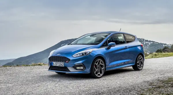 Niebieski Ford Fiesta ST na górskiej drodze, gotowy na każdą przygodę.