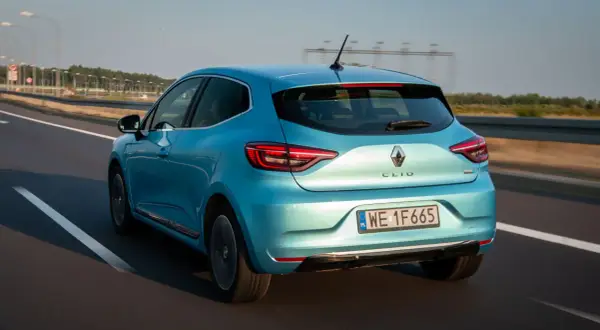 Błękitne renault clio 2024 pędzi autostradą, jego sylwetka pięknie odbija światło.