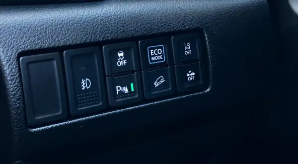 Przycisk "ECO MODE" w samochodzie. To tryb jazdy, który pomaga oszczędzać paliwo.