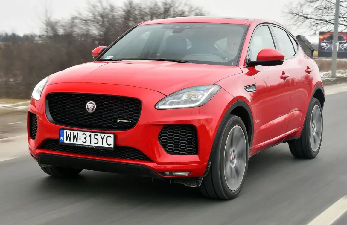 Czerwony Jaguar E-Pace pędzi po drodze, ukazując swoje sportowe linie i charakterystyczny grill.