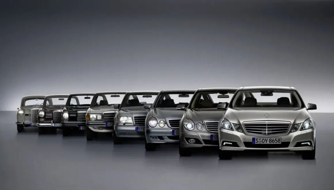 Rząd klasycznych i nowoczesnych Mercedesów klasy E, od starszych modeli po najnowsze, prezentuje ewolucję designu.