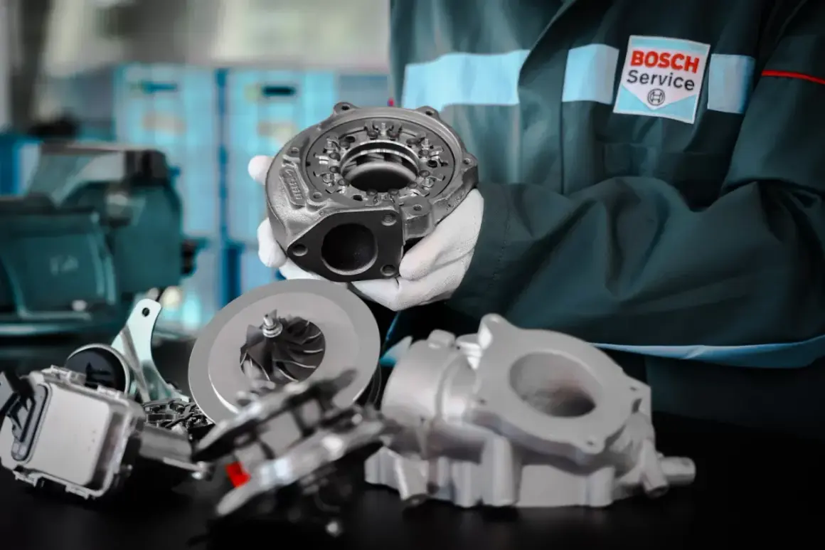 Mechanik w rękawiczkach prezentuje części turbosprężarki. Dowiedz się, na jakich obrotach jeździć benzyna, by silnik pracował optymalnie.