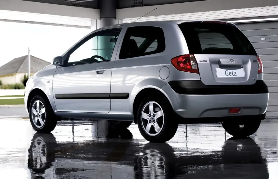 Srebrny Hyundai Getz 1.1 z 2005 roku, widok z tyłu, stoi na mokrej nawierzchni.