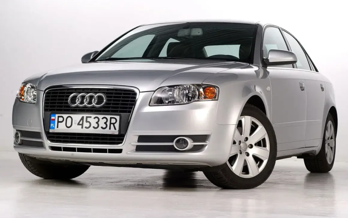 Srebrne Audi A4 B7 2.0 TDI z polskimi tablicami PO 4533R, prezentujące się na jasnym tle.