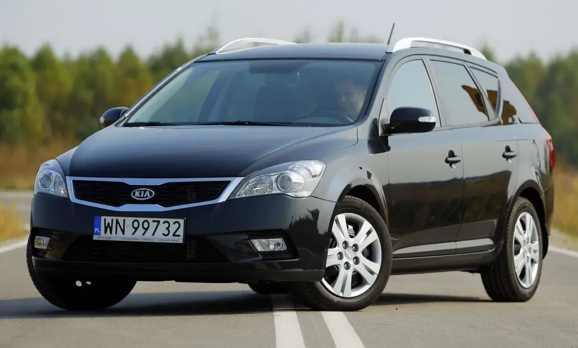 Czarny Kia Ceed 1. kombi na drodze, z kierowcą za kierownicą.