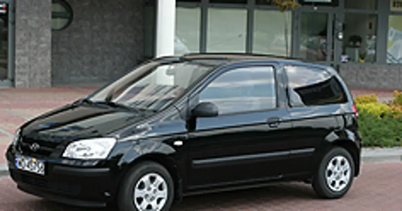 Czarny Hyundai Getz 1.1, miejski samochód, zaparkowany przed budynkiem.
