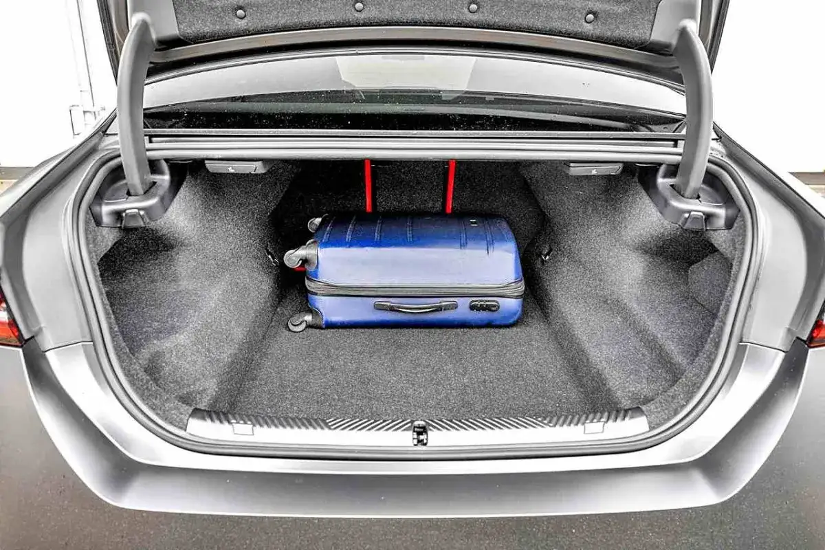 Bagażnik BMW M5 G30 mieści niebieską walizkę. Idealny na weekendowy wypad.