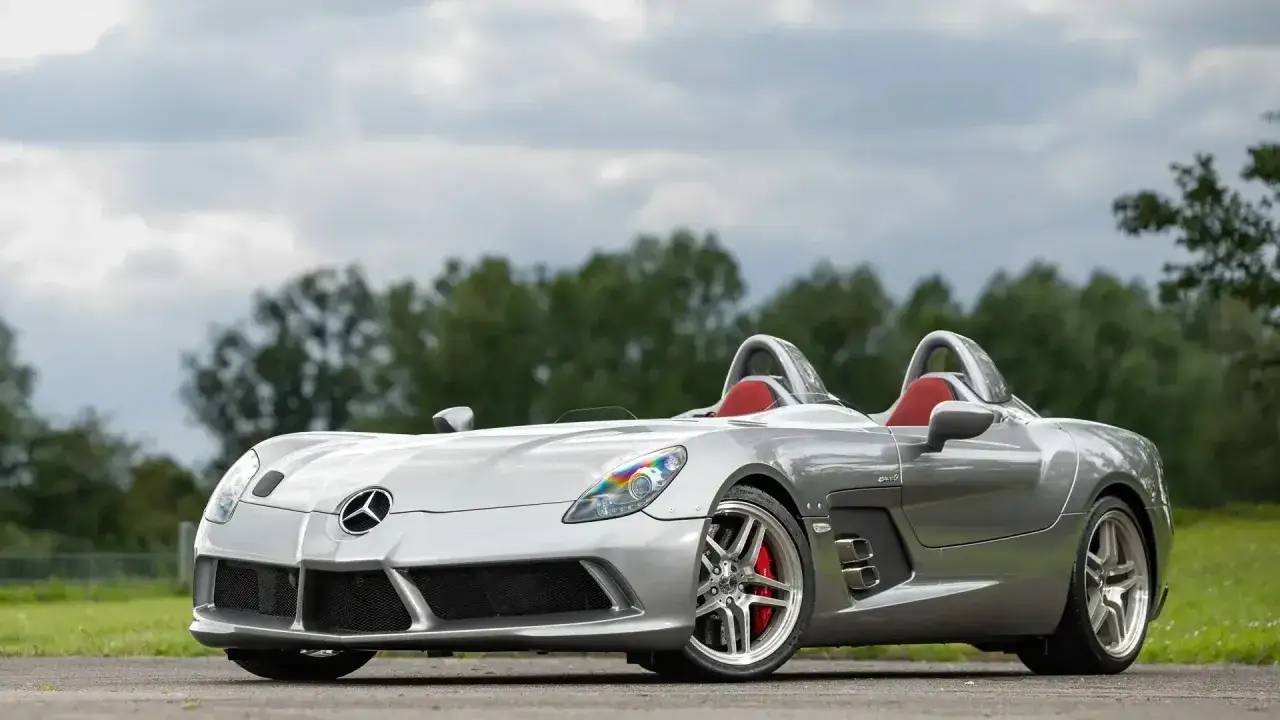Srebrny SLR McLaren z czerwonymi siedzeniami, gotowy do jazdy po otwartej drodze.