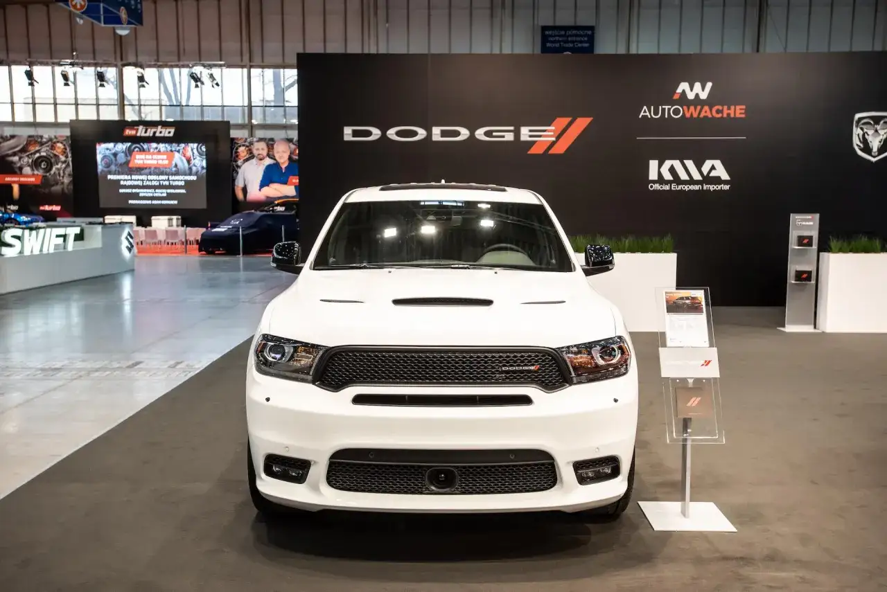 Biały Dodge Durango 5.7 Hemi na wystawie, z logo Dodge i Autowache w tle.