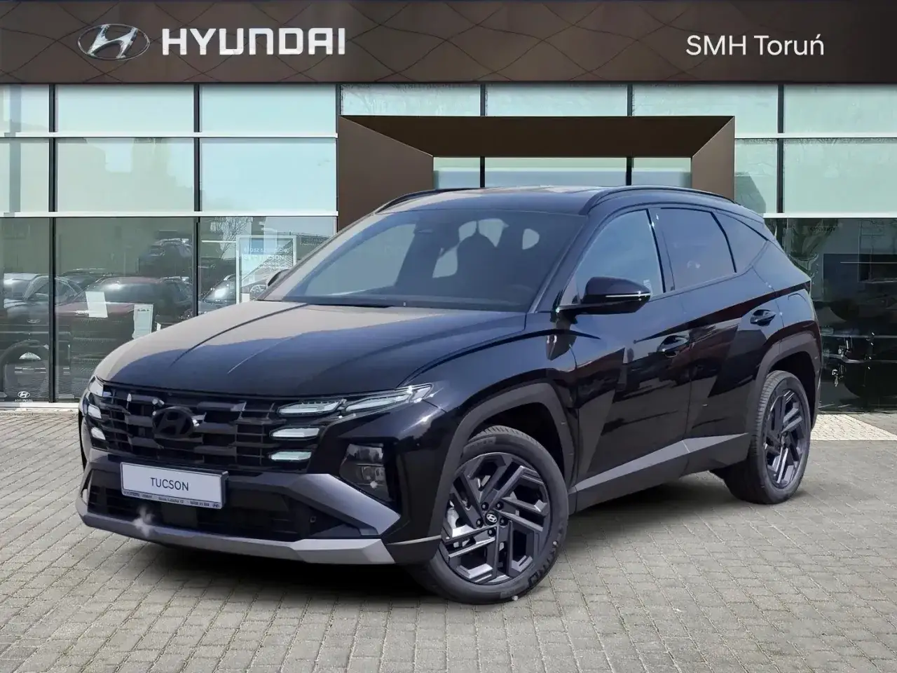 Czarny Hyundai Tucson 1.6 T-GDI lśni przed salonem SMH Toruń. Nowoczesny design i moc pod maską.