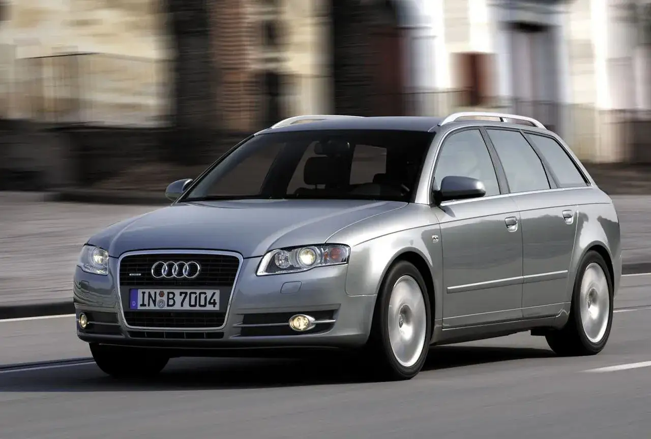 Srebrne Audi A4 B7 2.0 TDI Avant w ruchu miejskim, z rozmytym tłem budynków.