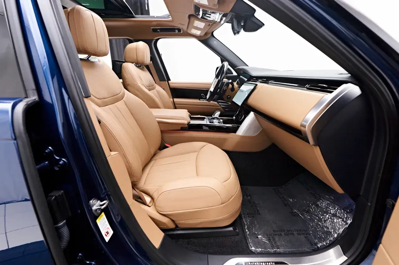 Wnętrze Range Rover Autobiography z beżową skórzaną tapicerką i nowoczesnym panelem.