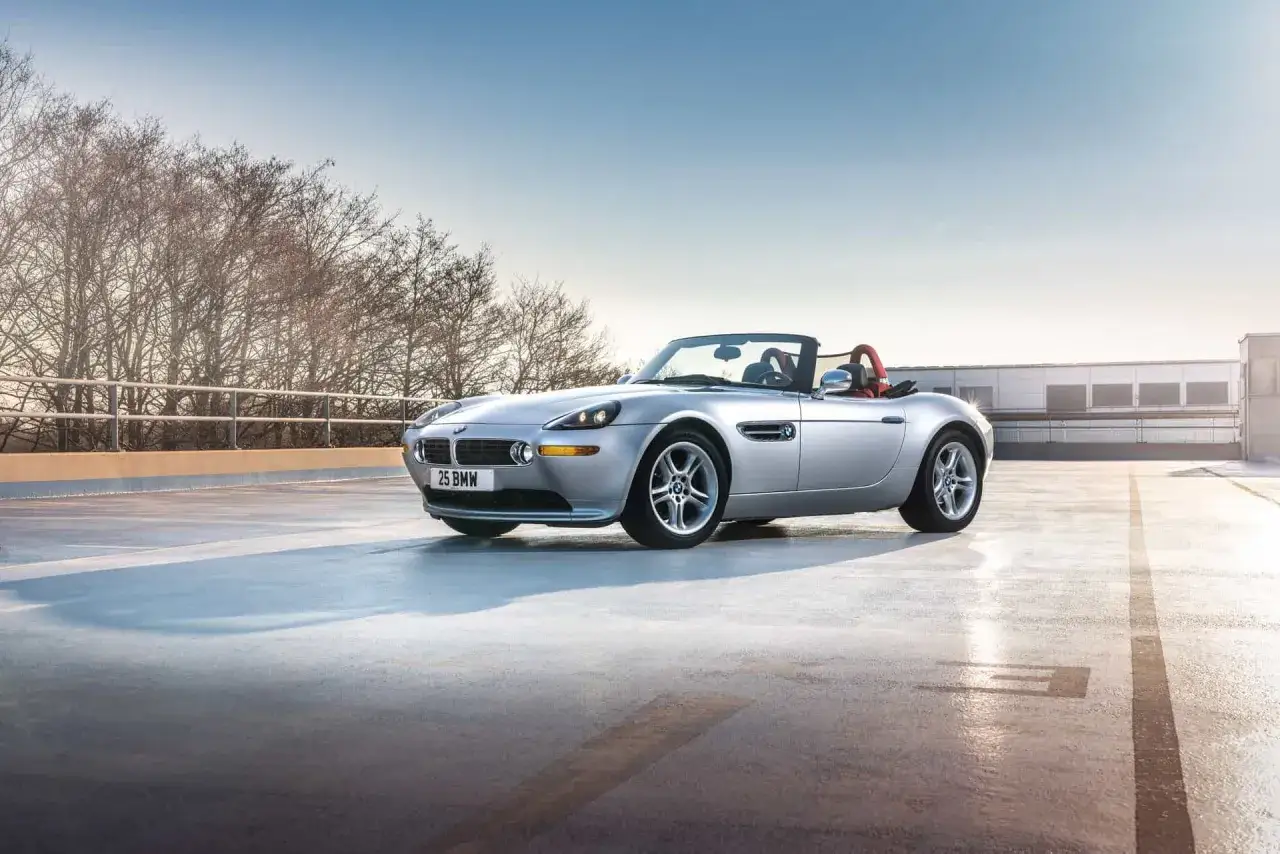 Srebrny kabriolet BMW Z8 z czerwonym wnętrzem stoi na betonowym parkingu.
