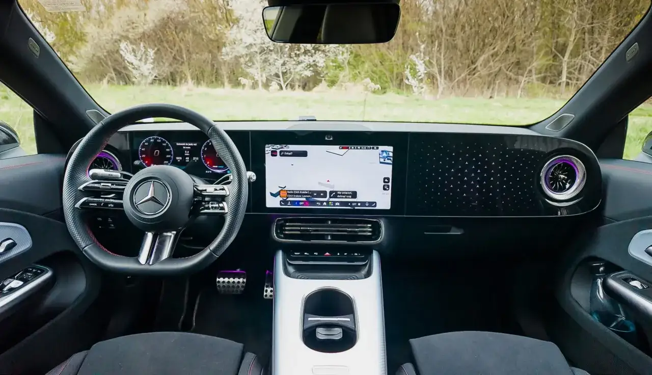 Wnętrze nowego Mercedesa CLA z ekranem nawigacji i cyfrowymi zegarami.