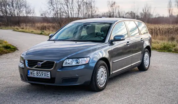Szary Volvo V50 1.6 diesel na drodze pośród jesiennej przyrody.