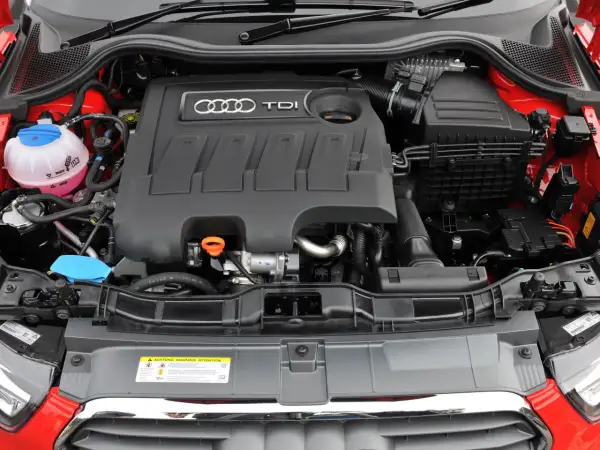 Silnik 1.6 TDI Audi z widocznym zbiorniczkiem płynu chłodniczego i osłoną silnika z logo TDI.