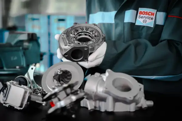 Mechanik w rękawiczkach prezentuje części turbosprężarki. Dowiedz się, na jakich obrotach jeździć benzyna, by silnik pracował optymalnie.