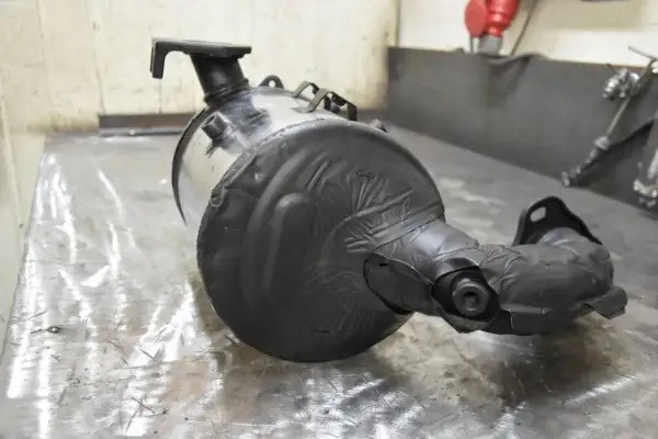 Element układu wydechowego, prawdopodobnie zapchany DPF. Objawy problemów z filtrem cząstek stałych mogą być widoczne na tym podzespole.