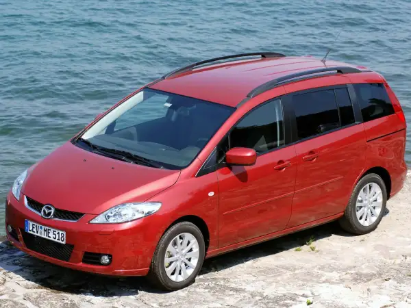 Czerwona Mazda 5 2.0 benzyna zaparkowana przy wodzie.